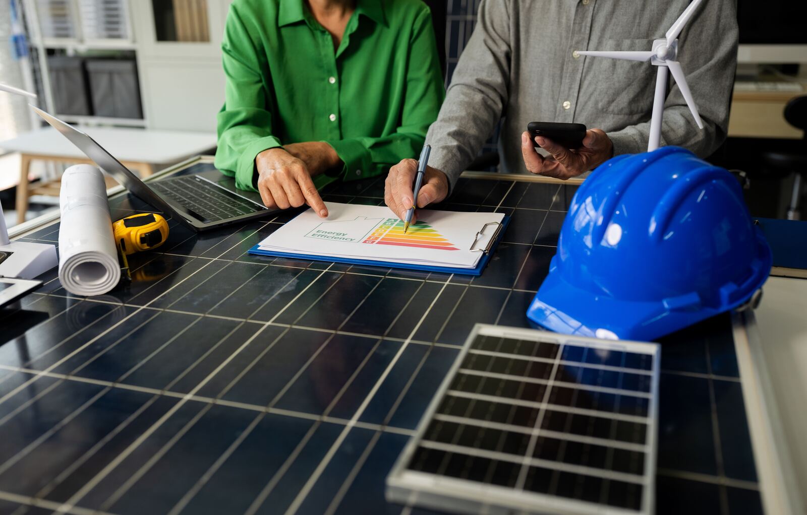 Beraterin und Berater von Günergie besprechen ein Energieeffizienz-Diagramm auf einem Solarmodul-Tisch